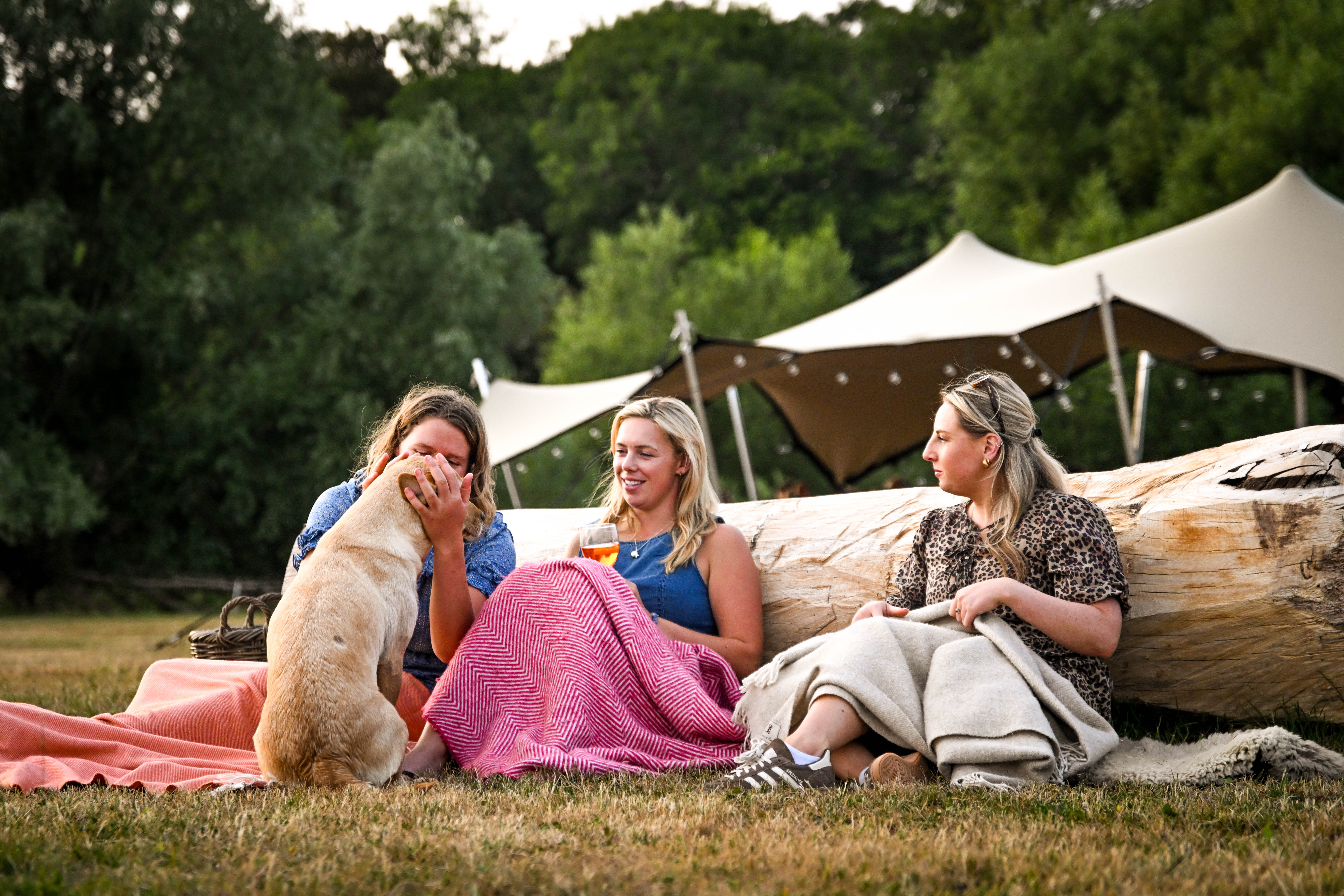 Guests relaxing with a dog at Hopnest glamping retreat